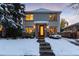 Charming home exterior featuring a walkway covered in snow and well-lit windows at 1385 Birch St, Denver, CO 80220