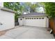 Spacious detached garage with a side door and a paved driveway, providing ample parking at 1385 Birch St, Denver, CO 80220