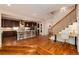 Open-concept kitchen with modern appliances, bar seating, and hardwood floors leading to the staircase at 1385 Birch St, Denver, CO 80220