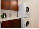 Practical laundry room with stackable washer/dryer unit and storage cabinets at 1385 Birch St, Denver, CO 80220