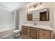 Bathroom features wood vanity with framed mirror, white countertop, and tiled shower at 1919 Newland Ct, Lakewood, CO 80214