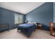 Bedroom with blue accent wall, carpeted floors, window view, and bedside table at 1919 Newland Ct, Lakewood, CO 80214