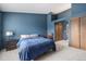 Bedroom with blue accent wall, carpeted floors, and closet storage with full-length doors at 1919 Newland Ct, Lakewood, CO 80214