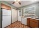 Corner view of the kitchen featuring wood-look floors, a double-door pantry, and white appliances at 1919 Newland Ct, Lakewood, CO 80214