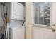 Laundry room with stackable washer and dryer and storage space, plus natural light at 1919 Newland Ct, Lakewood, CO 80214
