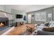 Bright living room with a cozy fireplace, modern TV, and stylish wood flooring at 1919 Newland Ct, Lakewood, CO 80214