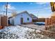 Backyard with a detached garage, patio area with modern blue outdoor furniture, and snow-dusted ground at 2431 N Ogden St, Denver, CO 80205