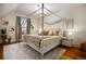 Beautiful primary bedroom featuring a four-poster bed, hardwood floors, and a lovely chandelier at 2431 N Ogden St, Denver, CO 80205