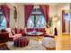 Comfortable living room featuring hardwood floors, an orange sofa, and an abundance of natural light from the windows at 2431 N Ogden St, Denver, CO 80205