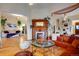 Bright living room showcasing hardwood floors, a fireplace, and an open layout leading to another living space at 2431 N Ogden St, Denver, CO 80205