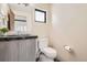 A powder room featuring a modern vanity with stone countertop, a sleek mirror, and a toilet at 1717 Irving St, Denver, CO 80204