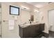 Double sink vanity bathroom featuring a marble countertop, dark wood cabinets, and modern lighting fixtures at 1717 Irving St, Denver, CO 80204