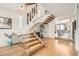 Staircase with floating wood steps, glass railings, and contemporary art, creating an open design at 1717 Irving St, Denver, CO 80204