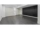 Finished basement living room, with dark floor, closet and accent wall at 13686 Dexter St, Thornton, CO 80602