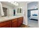 Well-lit bathroom with a double sink vanity and a clear view to a bright bedroom at 13686 Dexter St, Thornton, CO 80602