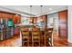 Open kitchen featuring an island with barstool seating, stainless steel appliances, and hardwood floors at 13686 Dexter St, Thornton, CO 80602