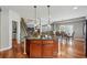 Kitchen island with cooktop, hardwood floors, and pendant lighting, open to the dining and living areas at 13686 Dexter St, Thornton, CO 80602