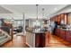 Open-concept kitchen with island, stainless steel appliances, and hardwood floors flowing into the dining and living areas at 13686 Dexter St, Thornton, CO 80602
