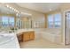 Bright bathroom features dual sinks, large mirror, soaking tub, and plenty of natural light at 10169 Briargrove Way, Highlands Ranch, CO 80126