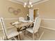 A dining room with a wooden table and chairs, complemented by a stylish chandelier and neutral decor at 10169 Briargrove Way, Highlands Ranch, CO 80126