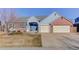 Charming home featuring a blue front door, brick accents, and a spacious two-car garage at 10169 Briargrove Way, Highlands Ranch, CO 80126