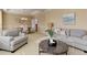 Elegant living room with neutral tones, comfortable seating, and view to dining area at 10169 Briargrove Way, Highlands Ranch, CO 80126