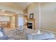 A vaulted ceiling and fireplace add warmth to the living room, open to a light-filled kitchen at 10169 Briargrove Way, Highlands Ranch, CO 80126