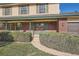 Charming home featuring a brick porch with green trim and shutters, and a walkway through the well-maintained landscaping at 1499 E Panama Dr, Centennial, CO 80121