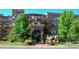 Beautiful brick apartment building with a grand arched entrance, surrounded by landscaped gardens and trees at 2700 E Cherry Creek S Dr # 302, Denver, CO 80209