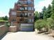 Brick apartment building shows multiple levels and underground parking with mature trees at 2700 E Cherry Creek S Dr # 302, Denver, CO 80209