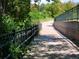 Scenic walkway lined with trees and a metal fence at 2700 E Cherry Creek S Dr # 302, Denver, CO 80209