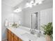 Modern bathroom with double sinks, wood cabinets, and bright lighting above a large mirror at 5174 W 123Rd Pl, Broomfield, CO 80020