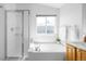 Relaxing bathroom featuring separate shower and tub with natural light from large window at 5174 W 123Rd Pl, Broomfield, CO 80020