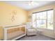 Cozy Bedroom with a white crib, comfortable chair, and a sunny window with neighborhood views at 5174 W 123Rd Pl, Broomfield, CO 80020