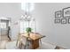 Bright dining room with a modern chandelier, bay window, and wood table at 5174 W 123Rd Pl, Broomfield, CO 80020