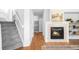 Open-concept living area showcasing a cozy fireplace with decorative tile and adjacent staircase at 5174 W 123Rd Pl, Broomfield, CO 80020