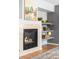Inviting fireplace with decorative tile surround and mantel, complemented by stylish shelving at 5174 W 123Rd Pl, Broomfield, CO 80020