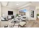 Bright living room with modern decor, plush seating, and a large window for natural light at 308 Josef Cir, Fort Lupton, CO 80621