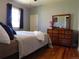 Comfortable bedroom features natural light, a dresser with mirror, and hardwood floors at 9180 Spruce Mountain Rd, Larkspur, CO 80118