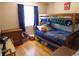 Cozy bedroom featuring a wooden bunk bed, hardwood floors and a window with blue curtains at 9180 Spruce Mountain Rd, Larkspur, CO 80118