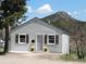 Charming stucco home featuring a quaint front yard with a mountain backdrop and lovely curb appeal at 9180 Spruce Mountain Rd, Larkspur, CO 80118