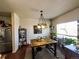 Well-lit dining room features unique light fixture, plants and a view to the kitchen at 541 Park Blvd, Brighton, CO 80603