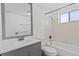 A white bathroom features a tub/shower combo, and a gray vanity with a sink and a mirror at 800 W Belleview Ave # 201, Englewood, CO 80110