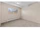 A view of a bedroom featuring neutral carpet and paint, baseboard heater, and a window at 800 W Belleview Ave # 201, Englewood, CO 80110