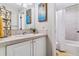 Bright bathroom featuring white vanity, a stylish mirror, decorative art, and a tub with shower at 566 N Humboldt St, Denver, CO 80218
