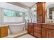 Luxurious bathroom features a soaking tub, a large window, and a wood vanity at 566 N Humboldt St, Denver, CO 80218