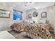 Bright bedroom with two twin beds, each with decorative floral covers, plus a window and wall art at 566 N Humboldt St, Denver, CO 80218