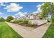 A row of townhomes is landscaped with rocks, green plants, and a white picket fence at 11386 Grove St # B, Westminster, CO 80031