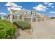 Street view of townhomes with stone accents, two-car garages, and manicured landscaping at 11386 Grove St # B, Westminster, CO 80031