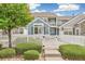 Charming townhome featuring a white picket fence, lush landscaping, and a welcoming entryway at 11386 Grove St # B, Westminster, CO 80031